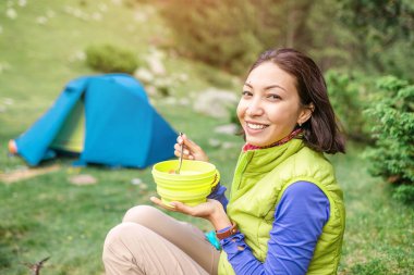 -Ormanda sabah sıcak kahvaltı kadın dağda kamp çadırı yakınındaki sıcak yemek yeme uzun yürüyüşe çıkan kimse