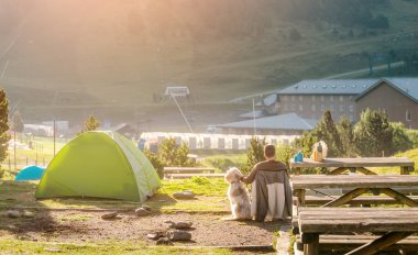 tarafından kamp çadır oturan adam ile onun evde beslenen hayvan köpek