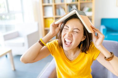 Kızgın ve stresli kitaplarla masada oturan kadın. Eğitim kavramı bıktım