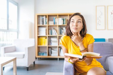 Eğitim kavramı. Düşünme ve ilginç bir fikir kitaplığındaki kitap okumak ise sahip mutlu öğrenci kadın