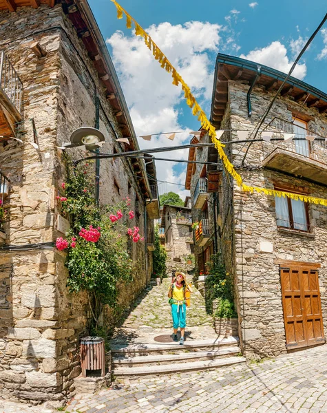 朝圣者妇女徒步者在穿过古老的中世纪小镇或村庄的路线小道 — 图库照片