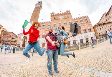 17 Ekim 2018, Siena, İtalya: İtalya arkadaş grubu ile seyahat. Gençler eğleniyor ünlü bir dönüm noktası önünde Siena, Toskana kulede çok ırklı çeşitli grup