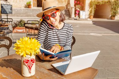 Dizüstü bilgisayar ve gadget'ları açık kafe, çalışma mutlu Genç Asyalı kadın portresi serbest çalışma ve kavram seyahat