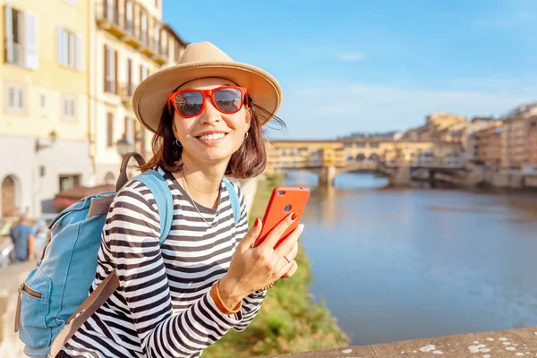 Happy traveler asian women on a vacation in Florence admiring view at the Ponte Vecchio famous landmark during trip in Italy, Europe