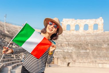 Verona - colosseum amfi tiyatro arena ünlü dönüm noktası önünde İtalyan bayrağı ile mutlu Genç Asyalı kadın. Tatil ve seyahat İtalya