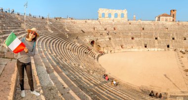 Verona - colosseum amfi tiyatro arena ünlü dönüm noktası önünde İtalyan bayrağı ile mutlu Genç Asyalı kadın. Tatil ve seyahat İtalya