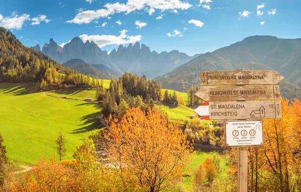 Hiking sign post, pointing at different routes in Funes Valley in Italian Dolomites Alps mountains