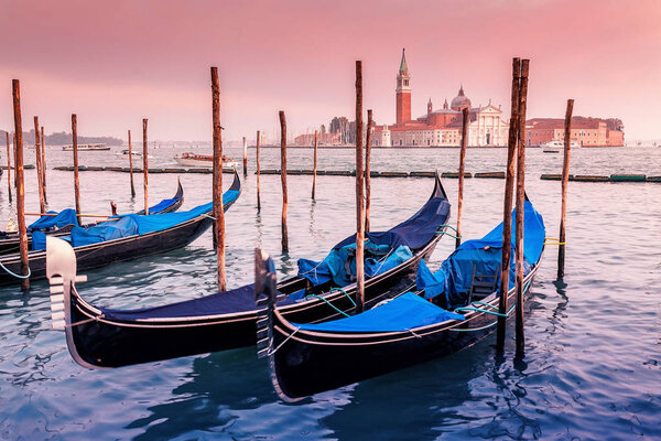 Majestic Gondolas in Venice at the sunset. Panoramic view of the San Giorgio Maggiore church from San Marco square. Travel and Vacation in Italy concept