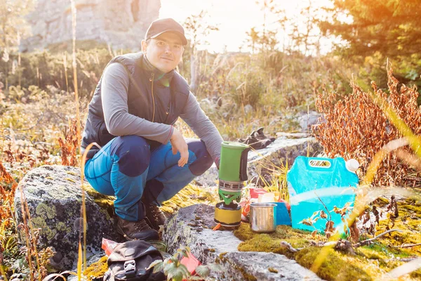 Adam uzun yürüyüşe çıkan kimse gıda turizm camp yakınındaki bir gaz brülör üzerinde hazırlar