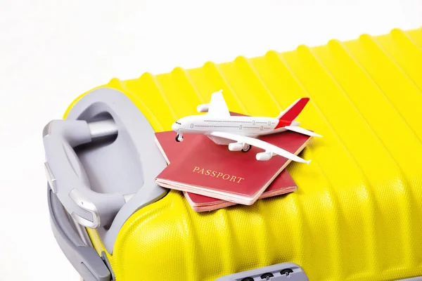 Repülő játék, a két Orosz Föderáció útleveleket egy sárga bőrönd — Stock Fotó
