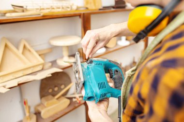 adam marangoz ahşap atölyesinde bir testere ile çalışma