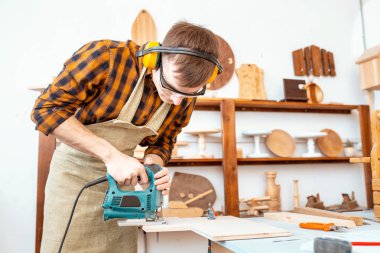 adam marangoz ahşap atölyesinde bir testere ile çalışma