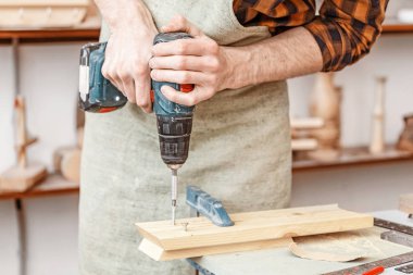 Marangozluk tornavida matkap ile çalışan adam. Tamirci becerileri 