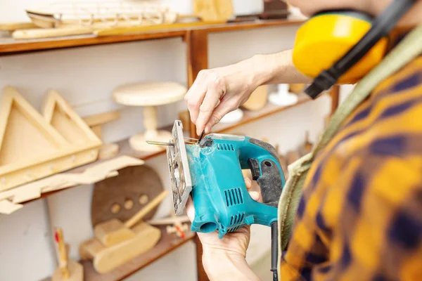 adam marangoz ahşap atölyesinde bir testere ile çalışma