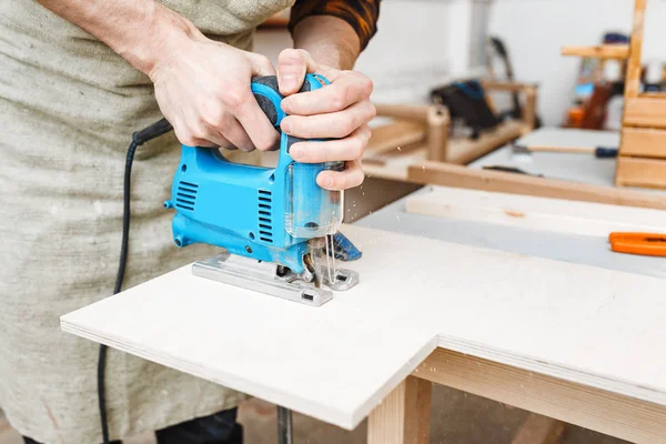 Carpintero hombre trabajando con un rompecabezas en madera en el taller —  Fotos de Stock