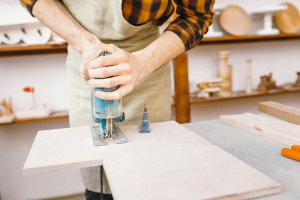 Carpintero hombre trabajando con un rompecabezas en madera en el taller — Foto de Stock