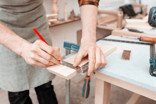 Male carpenter measuring wooden blank with the lines and making — Stock Photo, Image