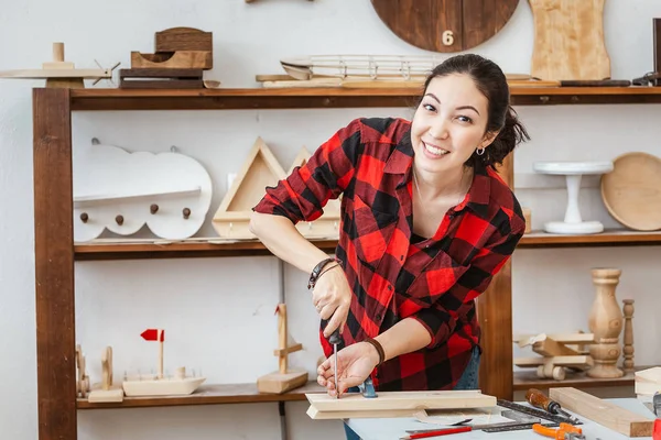 Woman working in carpentry workshop using screwdriver — Stock Photo, Image