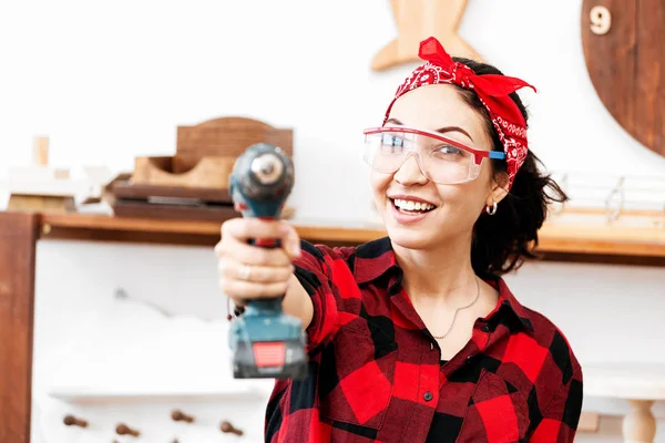 Woman with a drill screwdriver working in the workshop Studio al — Stock Photo, Image
