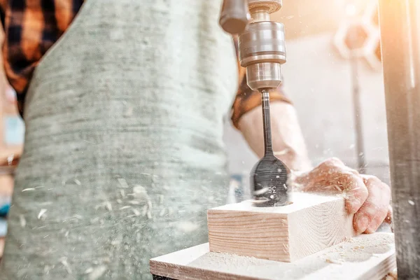 Close-up van een meubelmaker handen werken met hout op een draaibank boren — Stockfoto