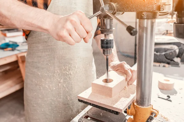 Close-up van een meubelmaker handen werken met hout op een draaibank boren — Stockfoto