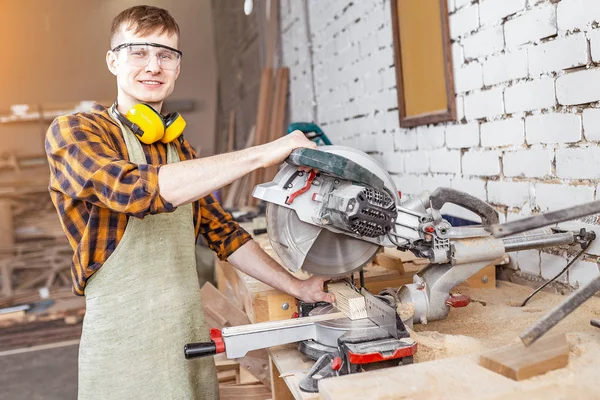 Male craftsman working with automated saw machine in factory or — Stock Photo, Image