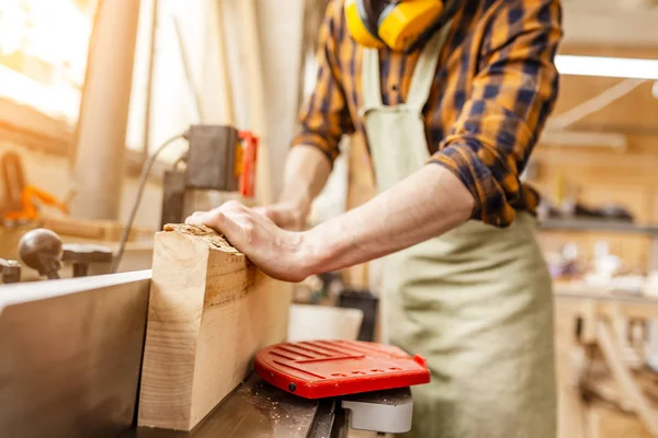 Man carpenter working with wooden workpieces at the construction — Stock Photo, Image