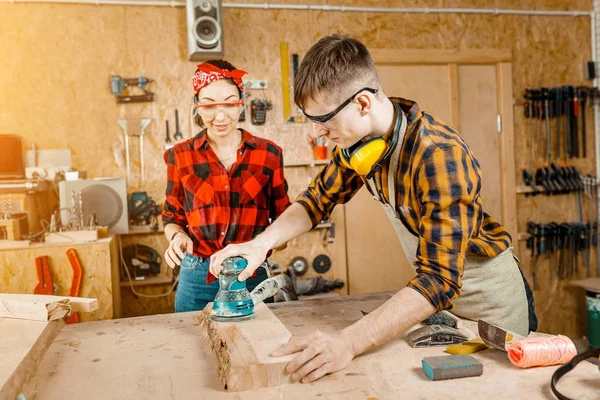 Man and woman as a team working in the workshop with wood and po — Stock Photo, Image