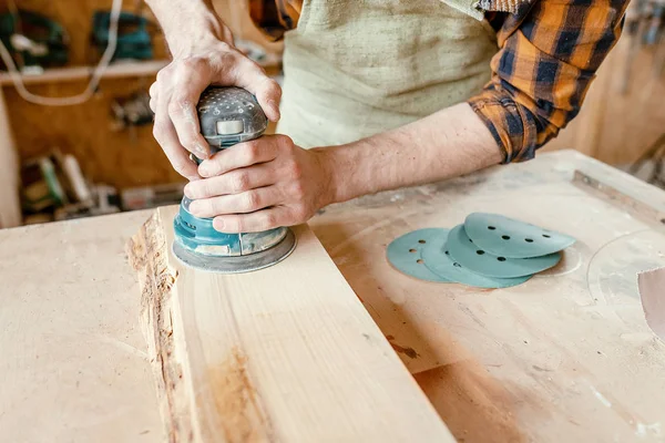 Man werkt in de winkel en een houten plank met grind ma poetsmiddelen — Stockfoto