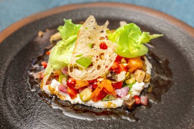 Restoranda koyu bir tabakta taze gurme salatası. Haute mutfağı kavramı