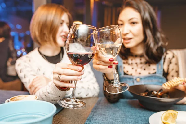 Две подруги веселятся и общаются, выпивая бокал вина в ресторане в ночном клубе. Понятие расслабления и дружелюбия — стоковое фото