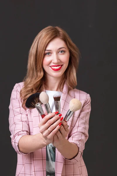 Woman make-up artist with brushes posing in Studio — Stock Photo, Image