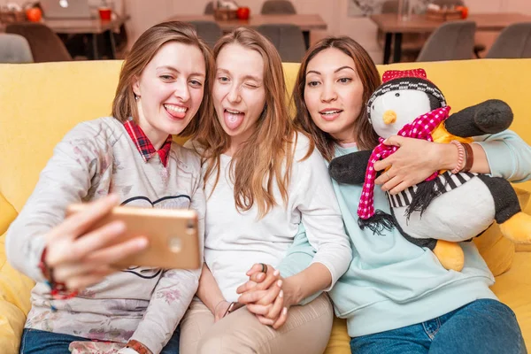 Ženské přátele Relaxujte na gauči a vezměte si selskou. — Stock fotografie