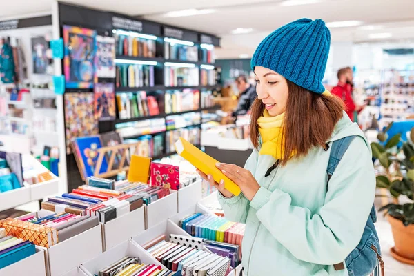 Jonge aziatische vrouw op zoek naar een boek in de winkel — Stockfoto