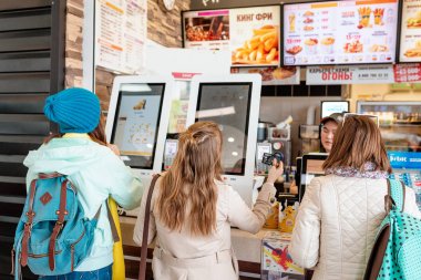 03 Mayıs 2019, Moskova, Rusya: Fastfood restoranı Burger King'de elektronik dokunmatik ekran terminal menüsünde kadın yemek siparişi verdi