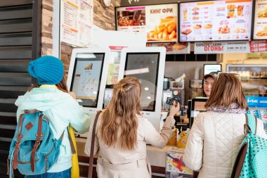 03 May 2019, Moscow, Russia: woman orders meal in the electronic touch screen terminal menu in the fastfood restaurant Burger King clipart