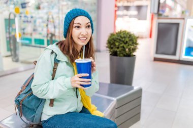 bir alışveriş merkezinde saman ile soda içme mutlu kadın