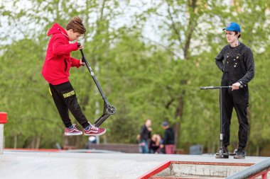 03 Mayıs 2019, Moskova, Rusya: Çocuklar rampalarda bir kaykay parkında scooter binmek ve bazı hileler yapıyor