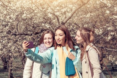 Bahar parkı, kardeşlik kavramı selfie fotoğraf yapma üç genç güzel kız