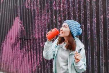 Genç hippi kadın modern gençlik mahallesinde kahve içiyor..