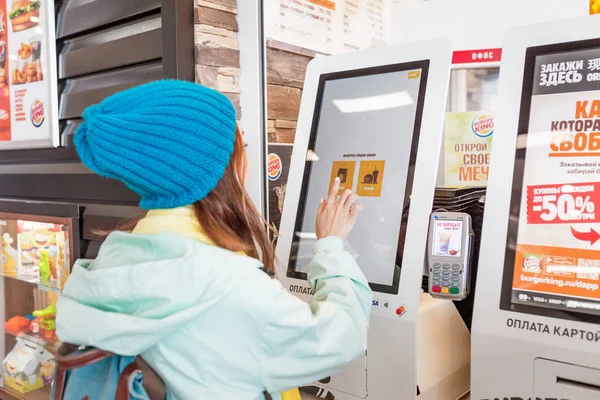 03 Mayıs 2019, Moskova, Rusya: Fastfood restoranı Burger King'de elektronik dokunmatik ekran terminal menüsünde kadın yemek siparişi verdi