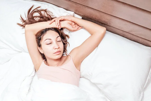 Asiatica donna dorme rilassato su un grande letto spazioso a casa o in un hotel — Foto Stock