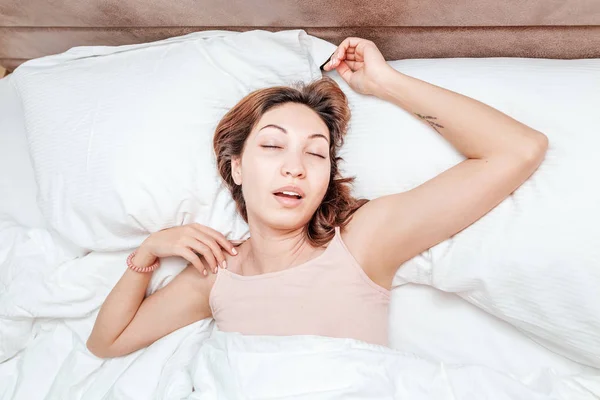 Asiatica donna dorme rilassato su un grande letto spazioso a casa o in un hotel — Foto Stock