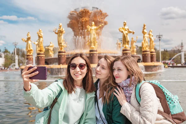 Skupina šťastných dívek cestuje v Moskvě a těší se úchvatným výhledem na palác VDNH. koncepce turistiky a vzdělávání — Stock fotografie