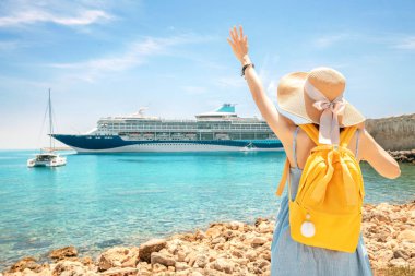 Büyük Cruise Liner Gemi bakarak, bir kıyı şeridinde sırt çantası ile mutlu kadın turist. Tur ve yaz tatili konseptinin satın alınması