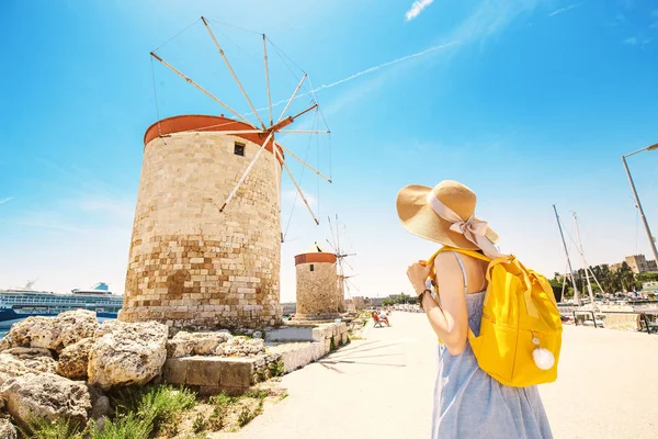 Menina viajante asiático feliz posando perto da famosa atração Rhodes moinhos de vento velhos. Férias na Grécia conceito — Fotografia de Stock