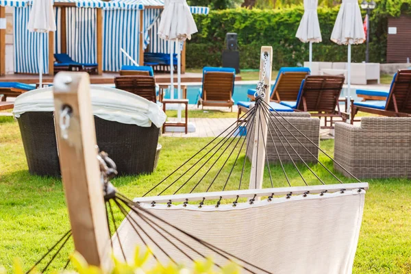 Amaca accogliente sulla terrazza con sedie a sdraio rotonde vicino alla piscina — Foto Stock