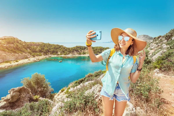 Азіатські дівчата в капелюсі займає selfie на фоні приголомшливий вид на Лазурний затоку в Середземному морі. Концепція подорожей, відпустки та мобільного зв'язку — стокове фото