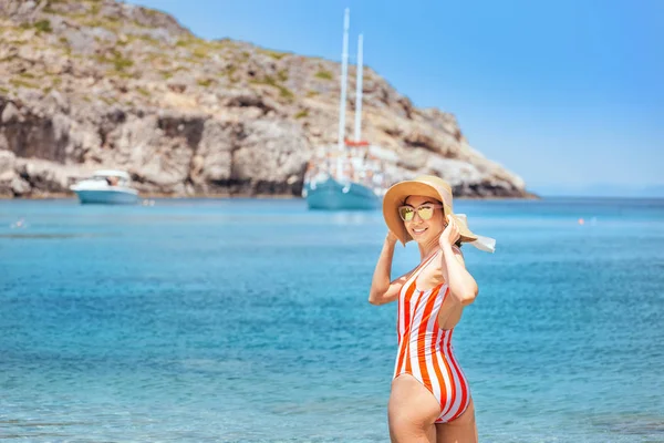 Femme en maillot de bain fermé reposant sur une station balnéaire tropicale avec yacht de luxe en arrière-plan — Photo