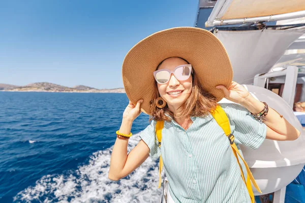 Happy asian woman in hat enjoying travel and vacation on Cruise ship. Tourist girl on the deck